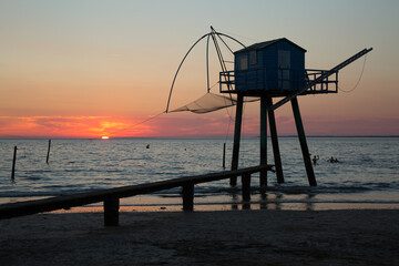 Fototapeta na wymiar Cabane au bord de la plage avec un coucher de soleil