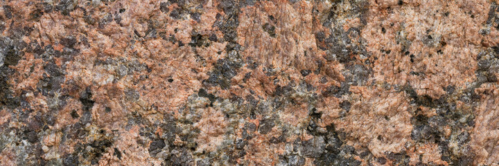 Granite texture. Natural pink granite with a grainy pattern. Stone background. Solid rough surface of rock. Durable construction and decoration material. Close-up.