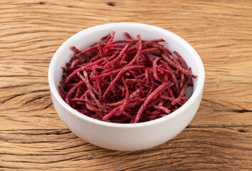 Beetroot strips, julienne style in a bowl over wooden table