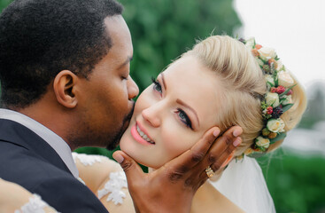 Fototapeta premium Groom kisses face of bride