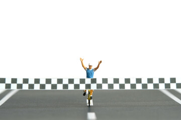 Miniature people toy figure photography. A biker with finish line, completed the bike competition,...