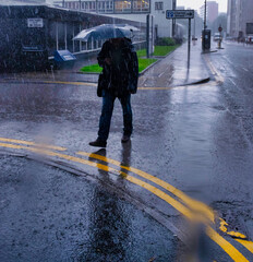 Man with umbrella walking on a rainy on the street
