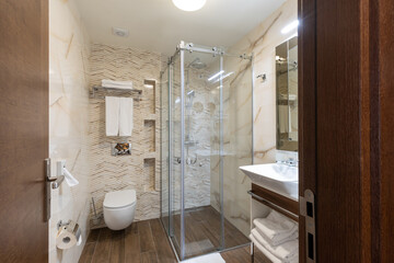 Interior of a hotel bathroom with glass shower cabin - obrazy, fototapety, plakaty