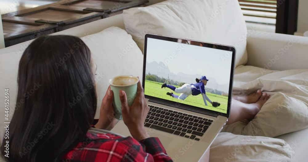 Poster Composite of woman sitting at home holding coffee watching baseball game on laptop