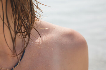 Woman's hair on the beach. Wet hair close up image. Hair damage due to salty ocean water and sun, summertime hair care concept.
