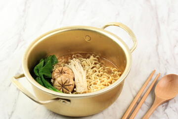 Korean Ramyeon Instant Noodle SOup on Golden Ramyeon Pot, Served with Mushroom and Boiled Vegetable