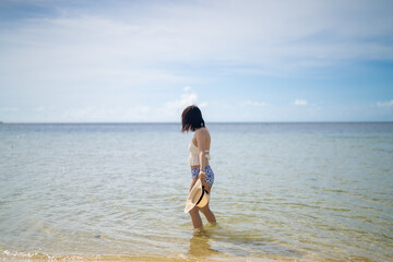 Fototapeta na wymiar 石垣島の海に水着の女性がいる風景 沖縄 Landscape with a woman in the sea in Ishigaki Island, Okinawa