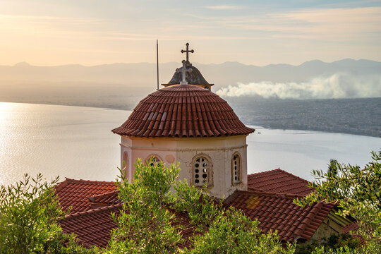 Iconic view of a typical Greek Orthodox church against a blue sunset sky
