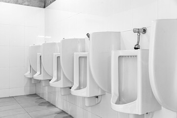Row of white ceramic urinals in the men's bathroom