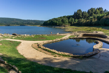 hot spring pool besides reservoir lake in Galicia landscape at daylight,