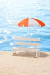 夏の砂浜と白いベンチとビーチパラソル