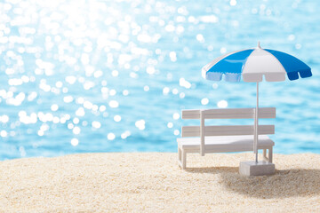 夏の砂浜と白いベンチとビーチパラソル
