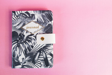 A plant pattern notebook on a pink background. Journaling. Productivity and studying concept. Handwriting. Copy-space