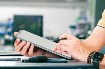 Cropped shot of man hand using tablet while sitting at office.