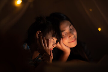 a women playing with child before sleep in children's tent. closeup happy face, lovely family...