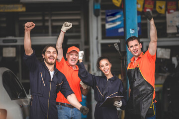 a portrait group photo of machanic team smilling in front of garage with thumb up, the professional engineer colleague in uniform, teamwork concept.