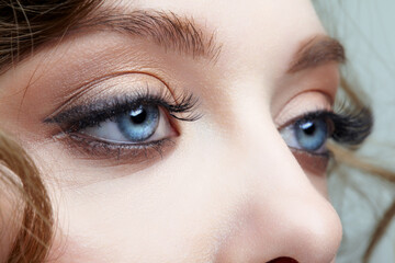 Closeup macro shot of blue human female eyes. Woman with natural face beauty makeup.