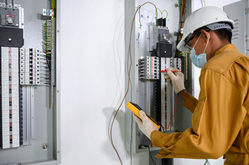 Electrician engineer using digital multimeter test current electric in control panel ​for testing...