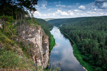 The rocky shore of a picturesque river. Rafting on catamarans on the flood