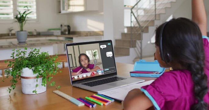 Schoolgirl using laptop for online lesson at home, with her school friend and web chat on screen