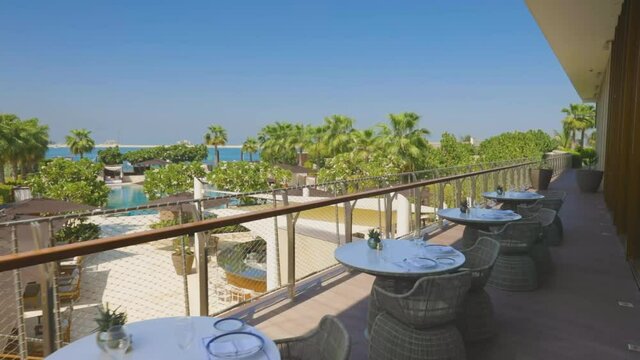Sliding to the side. Panoramic Balcony view of the beach coast or ocean water from restaurant, resort or vacation home in a tropical summer country.