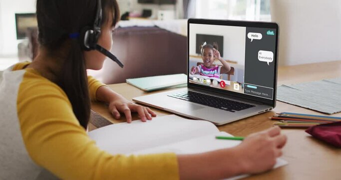 Schoolgirl using laptop for online lesson at home, with her colleague and web chat on screen