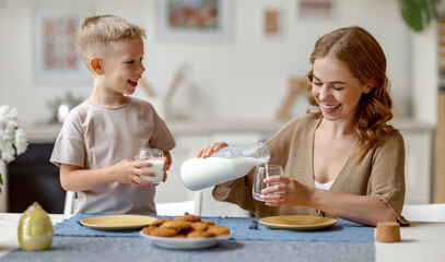 Mother pouring milk for son