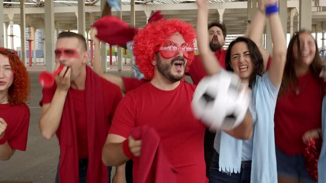 A group of people of different races enthusiastically celebrate the victory of their soccer team. The winning team chant chants after winning the league.