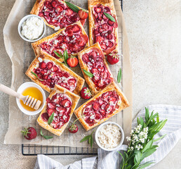 Delicious sweet sliced pies with strawberry. Puff pastry mini pies with strawberry, cream cheese,...