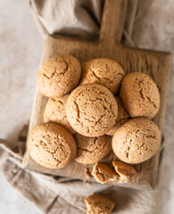Oatmeal cookies on wooden cutting board, brown concrete background. Healthy snack or dessert.
