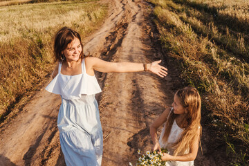 Young mother and daughter having fun outdoor.