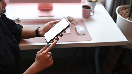 Young female using smart phone at her workplace.