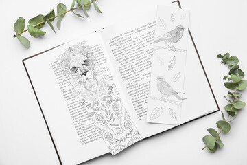 Book with bookmarks and eucalyptus branches on white background