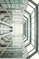 Fototapeta premium Low angle view of high modern building with big windows and glass ceiling