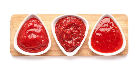 Bowls of chili sauces on white background