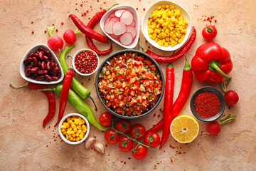 Bowl of tasty salsa sauce with products on color background