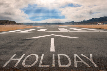 White arrow on a small asphalt air plane runway. Cloudy sky with