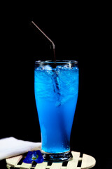 glass of blue hawaii isolated on wooden plate