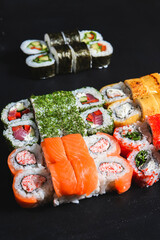 Sushi Set nigiri and sushi rolls served on black stone background. Japanese cuisine concept