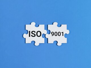 ISO 9001 certification on jigsaw puzzle pieces against blue background.