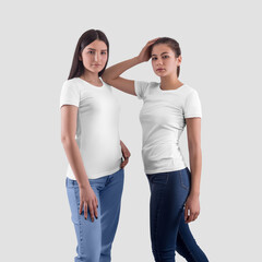 Mockup of a stylish white women's T-shirt on two dark-haired pretty girls in jeans, front view.