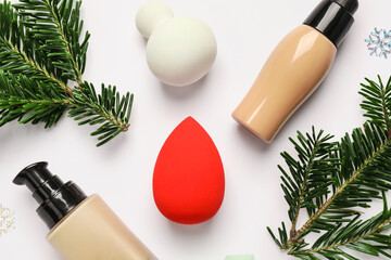 Christmas composition with makeup sponges and tonal foundation on white background
