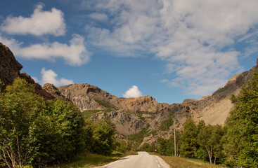 View of rocks with serpentine minerals, Leka, Norway. The island is Norway's geological national monument. Blue sky with white clouds. Horizontal. Warm colors of the sunlight.