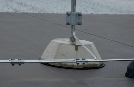 A lightning conductor is used to protect buildings from lightning that can damage a house or its electrical equipment is routed to the highest points of a green garden roof.