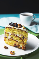 Pistachio cake, sponge cake with nuts decoration on a white plate.