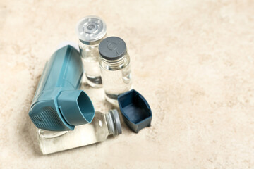 Modern inhaler and ampules on grunge background