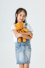 Portrait close up isolated studio shot of Asian happy girl in blue jeans denim skirt dungarees...