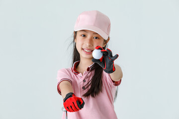 Close up isolated studio shot of golf ball in hand of Asian little professional girl kid golfer in...