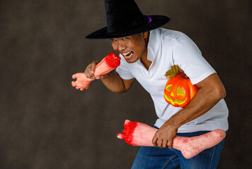 Portrait studio shot of Asian horror evil man in necromancer wizard costume with tall hat and...