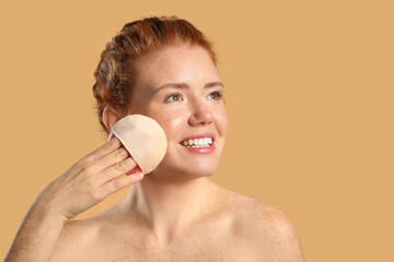 Beautiful young woman with makeup sponge on color background